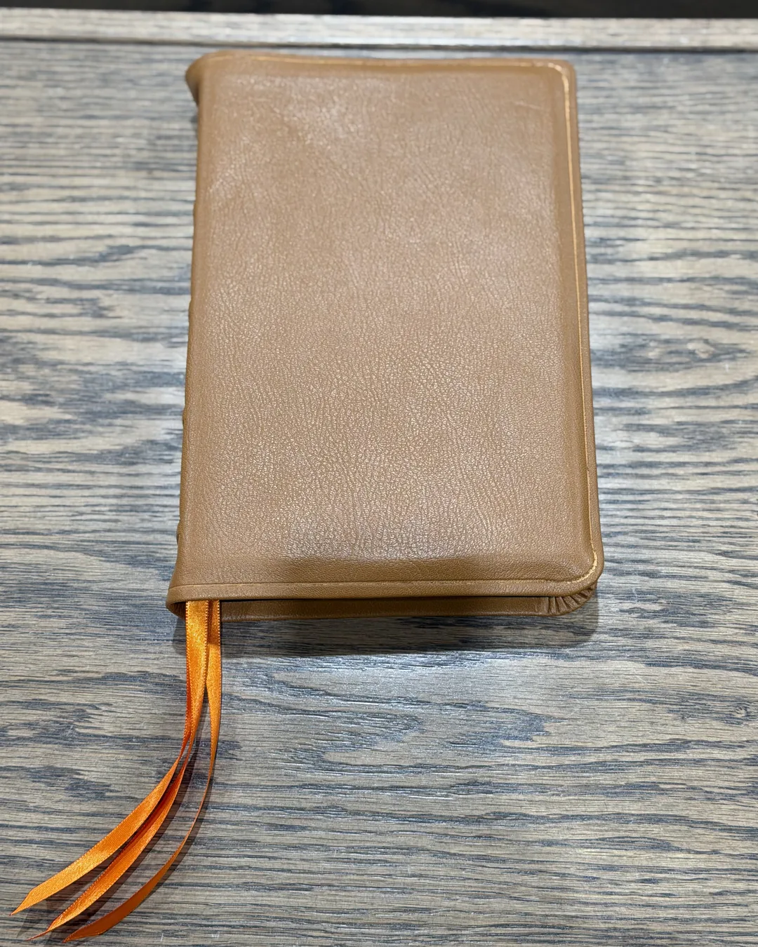 Tan leather Bible from above with orange ribbons